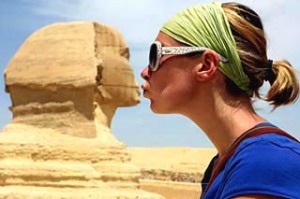 Woman pretending to kiss the Sphinx, Egypt. Solo travel.