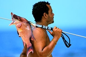 Belize, fisherman with catch slung over shoulder.