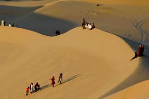 Residents walk on sand dunes in the Libyan desert oasis town of Ghadames