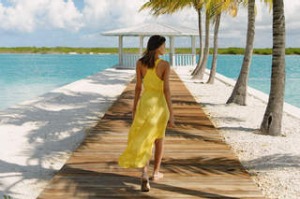Young woman strolling on beach pier, Providenciales, Turks and Caicos Islands, Caribbean.
