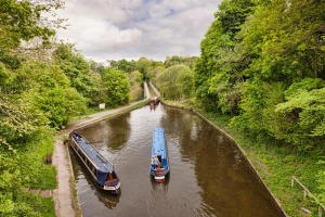Narrowboats in the Llangollen Canal, built by Thomas Telford, manoeuvering before crossing the Chirk Aqueduct.