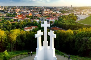 Aerial view of the Three Crosses monument overlooking Vilnius Old Town on sunset.