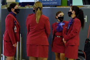 Virgin Australia staff wearing masks at Sydney Airport in December. Virgin crew are still required to wear masks on ...